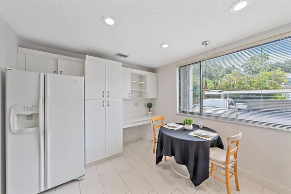 a very nice looking dining room with a large window a table and chairs