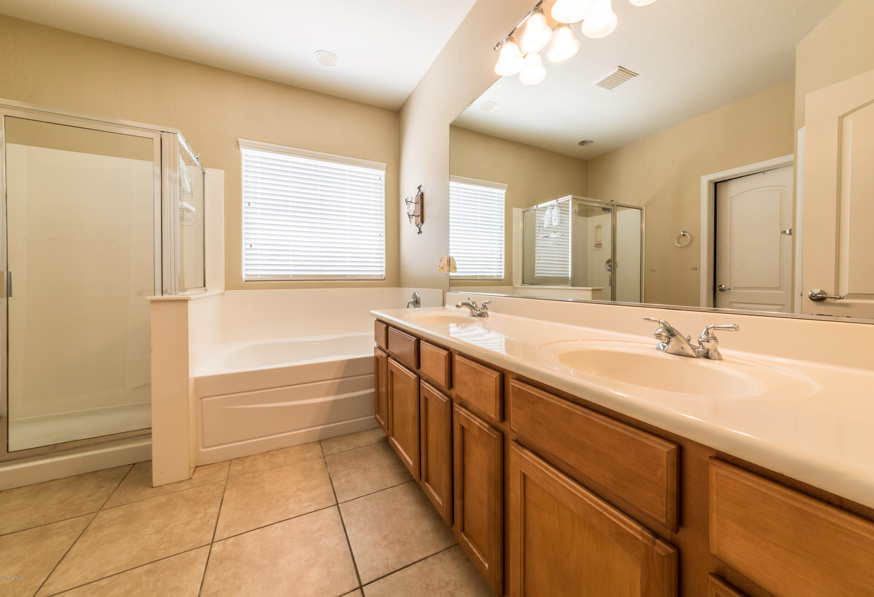 2872 North Point Ridge Road Buckeye, AZ 85396 - Photo 18 of 36 a spacious bathroom with a double vanity sink a mirror and a bathtub