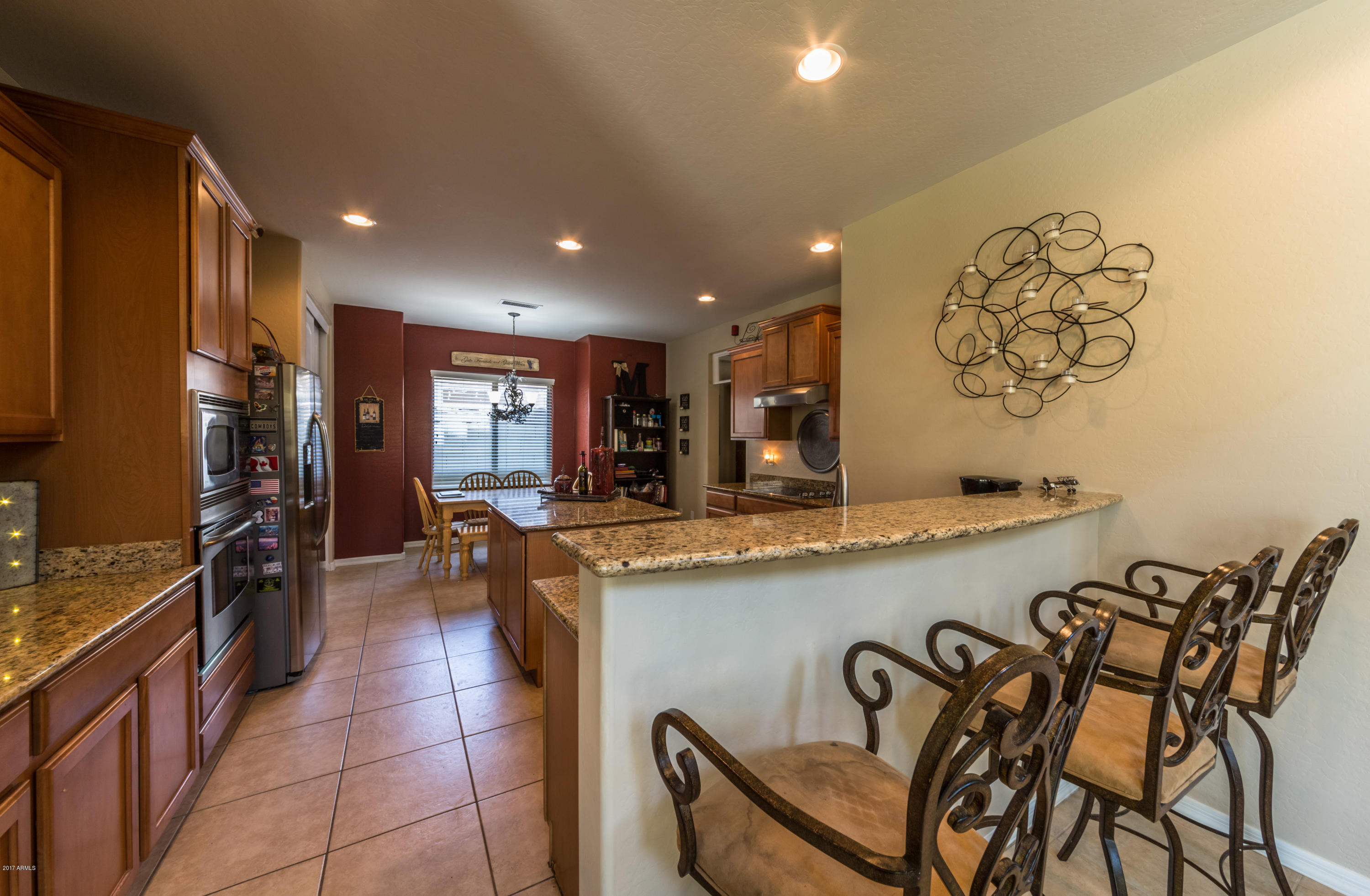 2872 North Point Ridge Road Buckeye, AZ 85396 - Photo 7 of 36 a kitchen with stainless steel appliances granite countertop a sink and a refrigerator