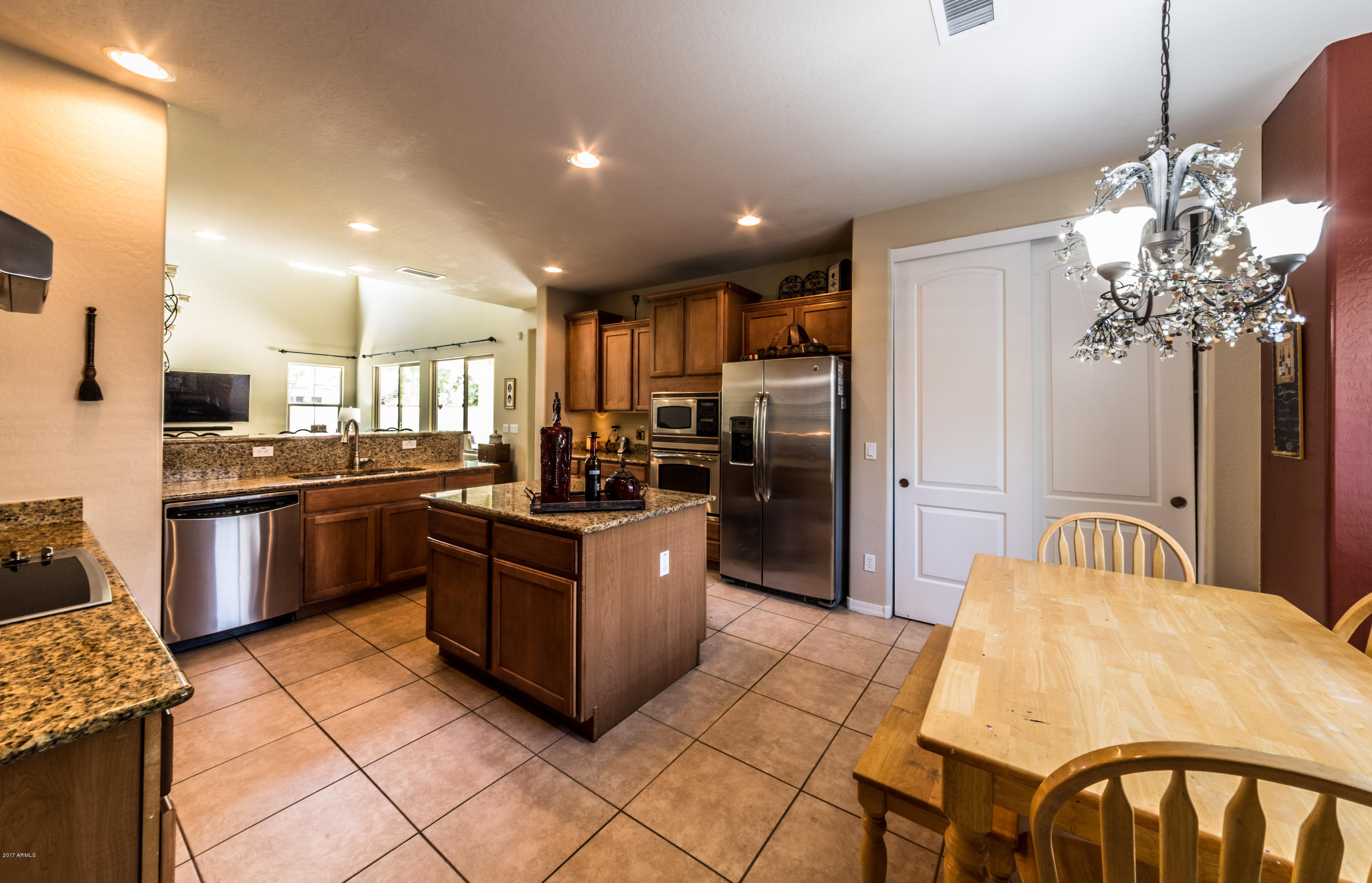 2872 North Point Ridge Road Buckeye, AZ 85396 - Photo 9 of 36 a kitchen with stainless steel appliances kitchen island granite countertop a refrigerator and a stove top oven