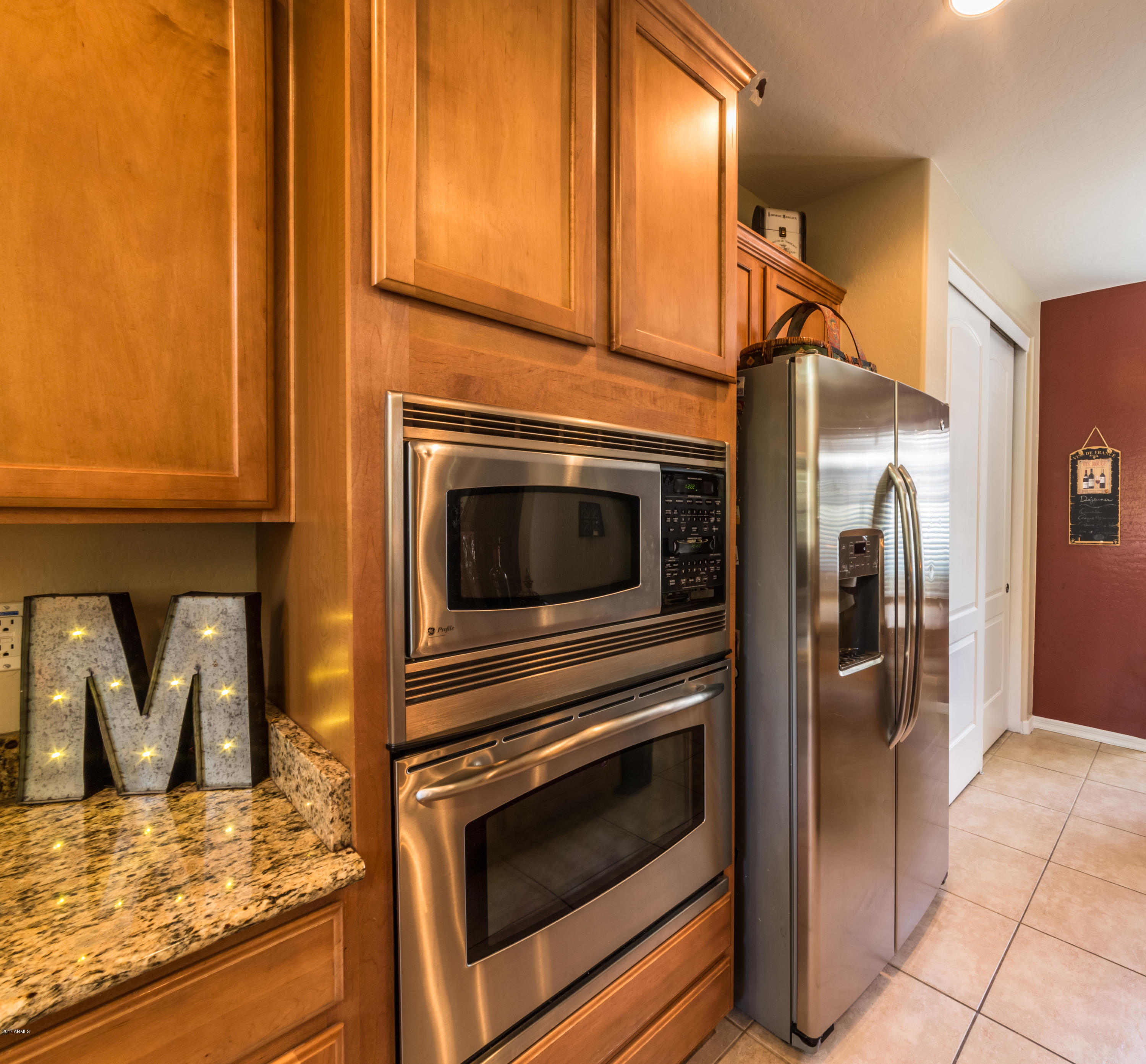 2872 North Point Ridge Road Buckeye, AZ 85396 - Photo 10 of 36 a kitchen with stainless steel appliances granite countertop a refrigerator and a stove top oven