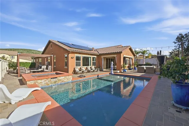 a view of a house with swimming pool and sitting area