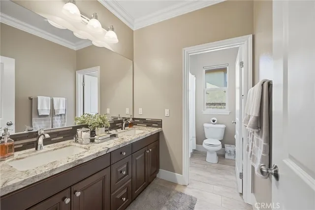 a spacious bathroom with a granite countertop sink a toilet and a mirror