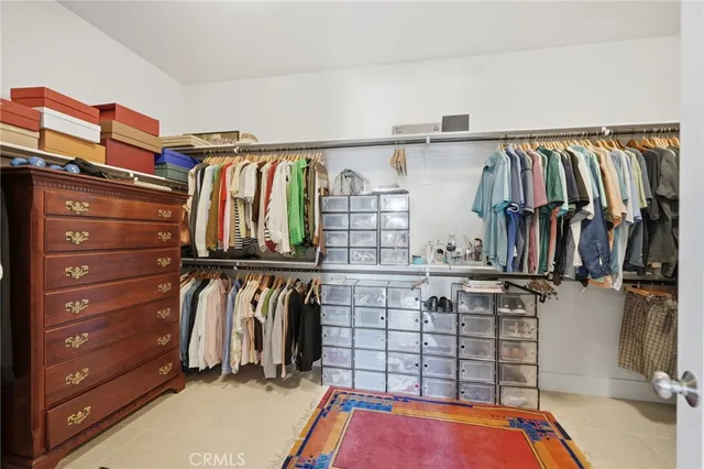 a view of walk in closet with clothes and shoes