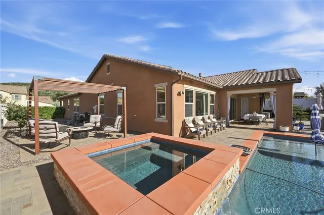 a view of a house with swimming pool and sitting area