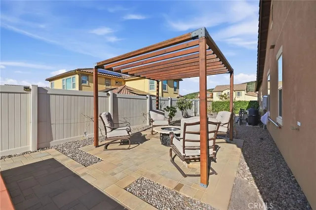 a patio with a table and chairs and potted plants