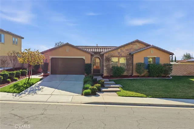a front view of a house with a garden and plants