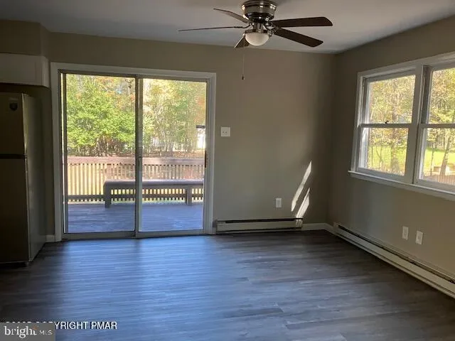a view of empty room with wooden floor and fan