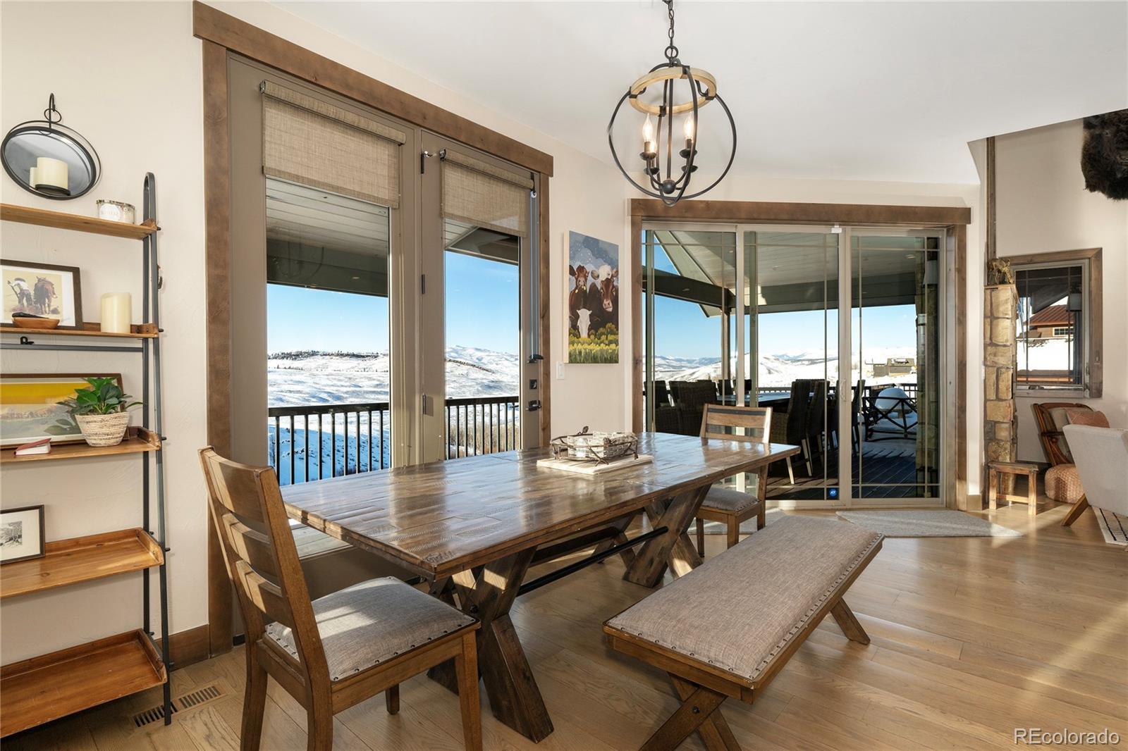 465 Lower Ranch View Drive Granby, CO 80446 - Photo 3 of 50 a dining room with wooden floor a chandelier a wooden table and chairs