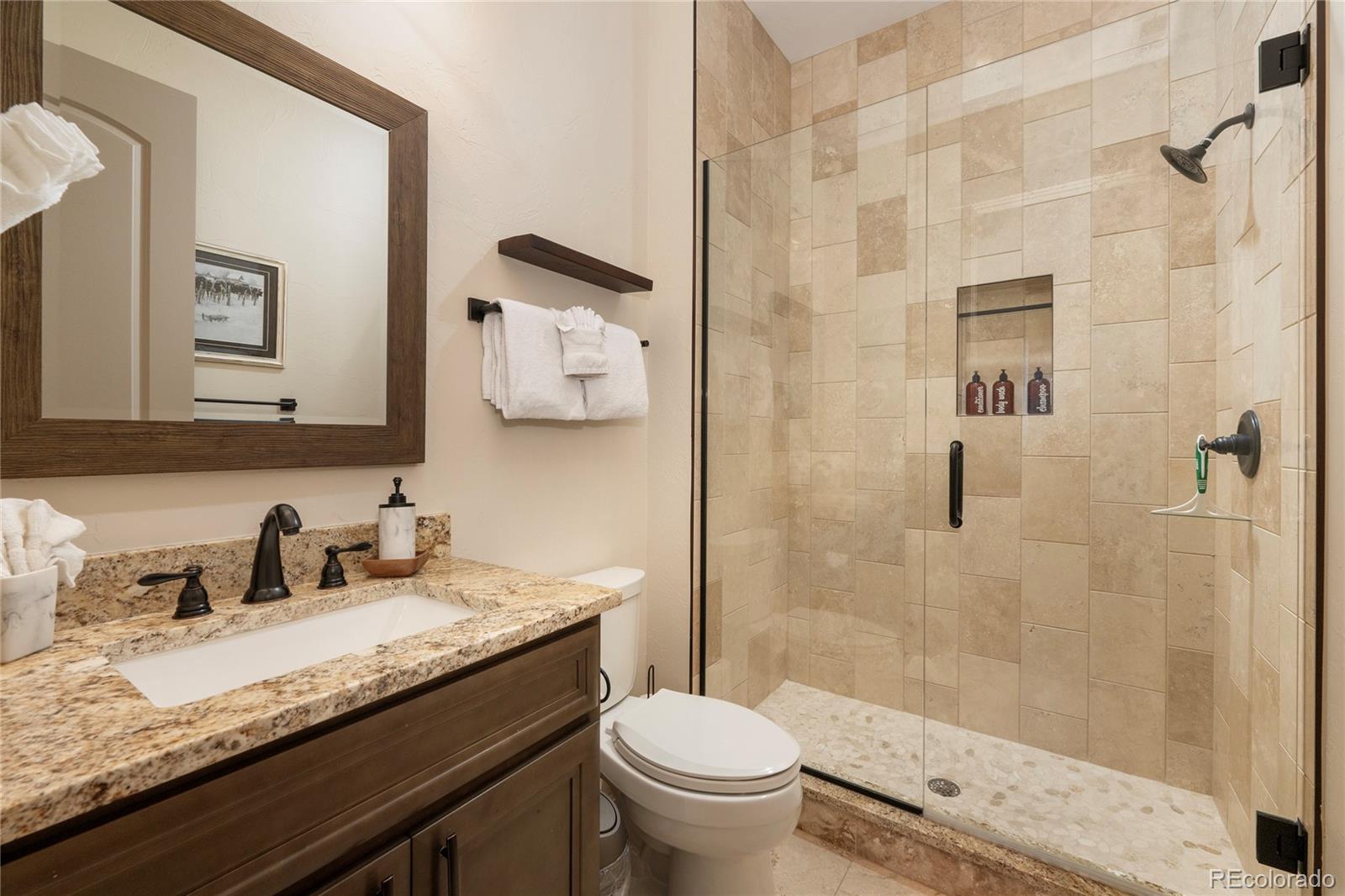 465 Lower Ranch View Drive Granby, CO 80446 - Photo 33 of 50 a bathroom with a granite countertop sink toilet and shower