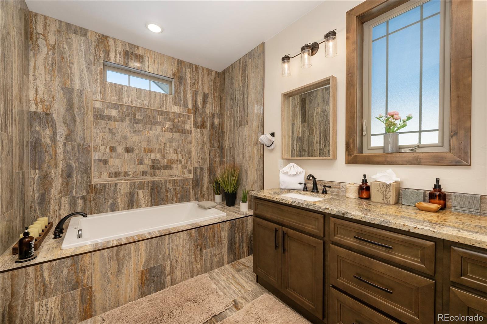 465 Lower Ranch View Drive Granby, CO 80446 - Photo 46 of 50 a bathroom with a granite countertop sink mirror and a bathtub