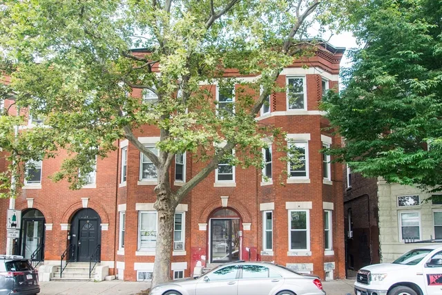 a front view of a residential apartment building with a yard