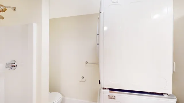 a white toilet sitting next to a shower