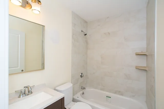 a bath room with a sink a toilet and shower