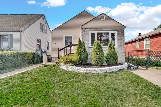 a view of a white house with a small yard and potted plants