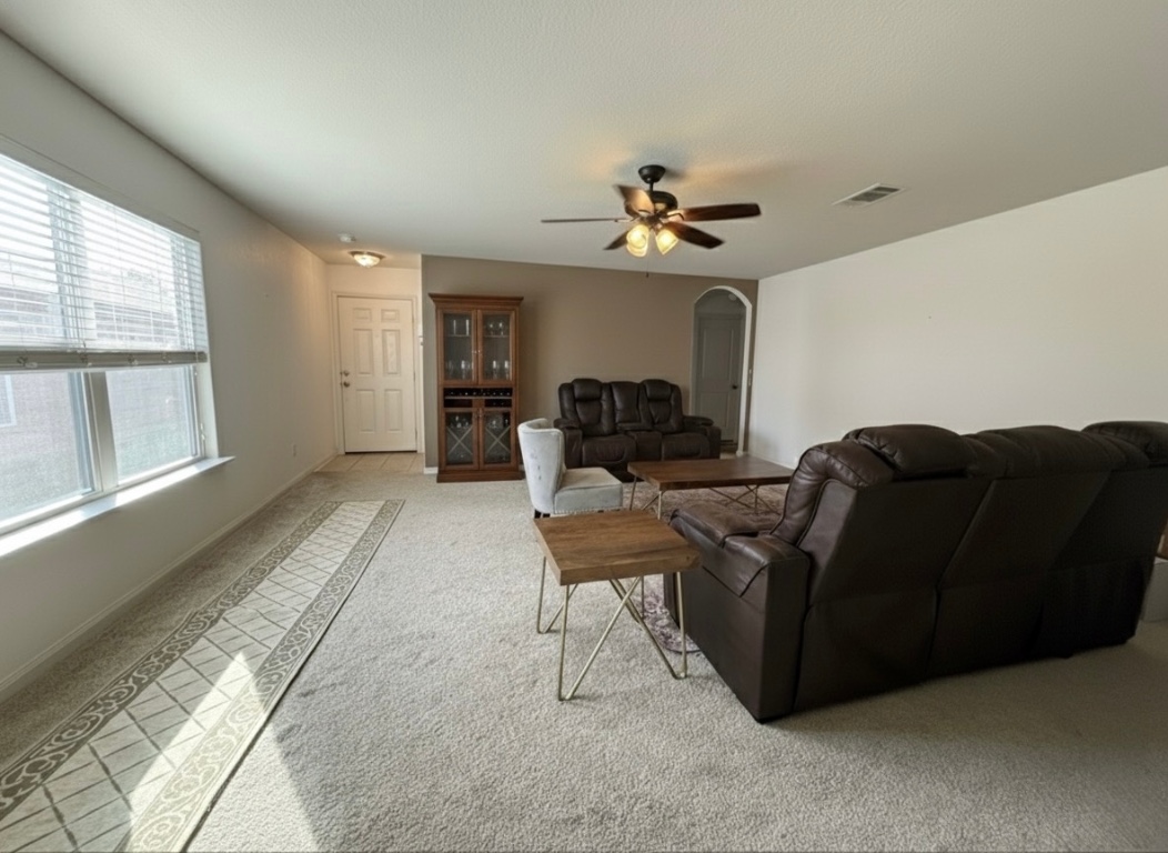 108 Koontz Loop Jarrell, TX 76537 - Photo 3 of 20 Living area featuring arched walkways, light colored carpet, and a ceiling fan
