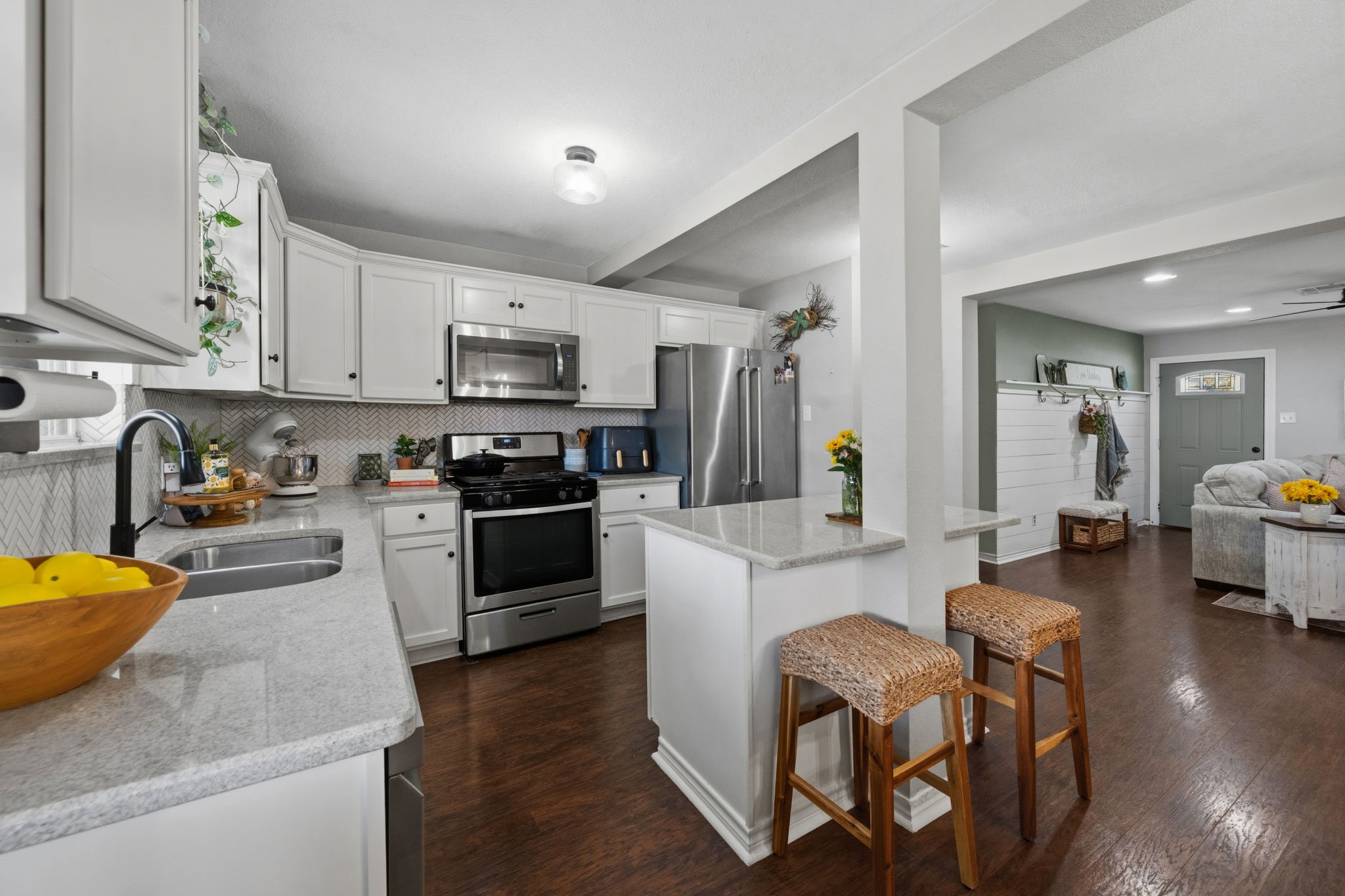431 Corydon Drive Houston, TX 77336 - Photo 12 of 26 Bright and functional kitchen showcasing crisp white cabinetry, generous counter space, and a breakfast bar for casual seating.
