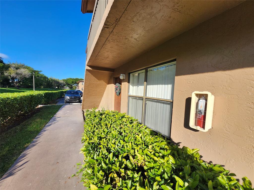 10004 Winding Lake Road, Unit 101 Sunrise, FL 33351 - Photo 1 of 17 a front view of a house with garden