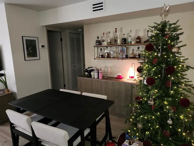 a living room with a table chair and a potted plant