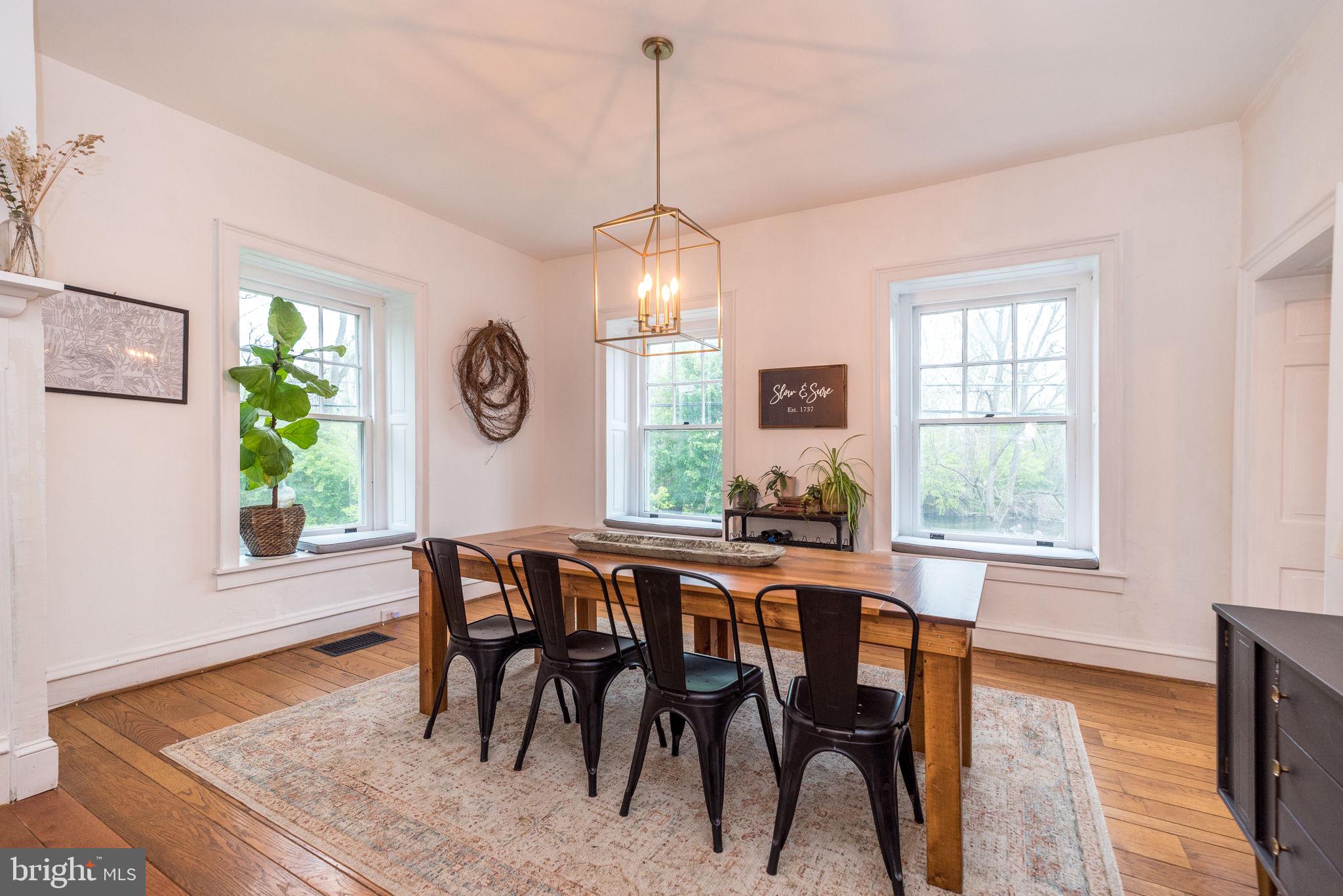 866 Schuylkill Road Birdsboro, PA 19508 - Photo 17 of 73 a dining room with wooden floor a chandelier a wooden table and chairs