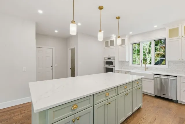 a kitchen with a sink and dishwasher with wooden floor