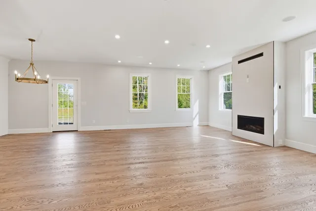 an empty room with windows and fireplace