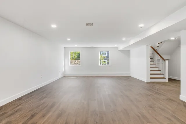 an empty room with wooden floors and window