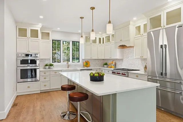 a kitchen with stainless steel appliances a stove a sink a refrigerator and cabinets