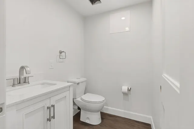 a bathroom with a toilet a sink and mirror