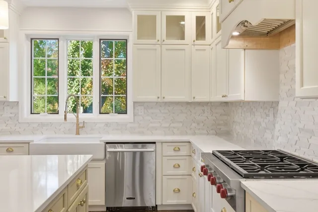 a kitchen with granite countertop a sink a stove and cabinets