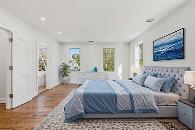 a spacious bedroom with a bed and a painting on the wall