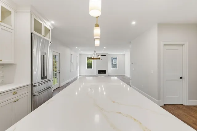 a large white kitchen with refrigerator and window
