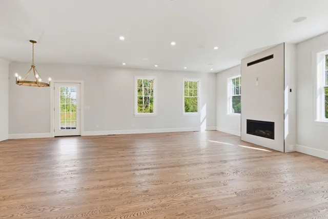 an empty room with windows and fireplace
