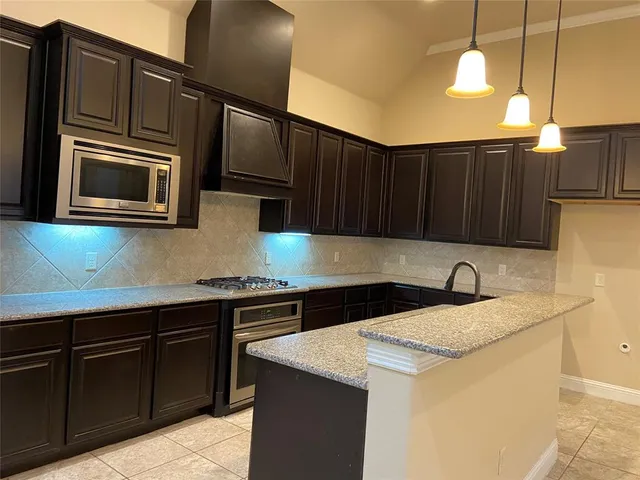 a kitchen with granite countertop cabinets and steel stainless steel appliances
