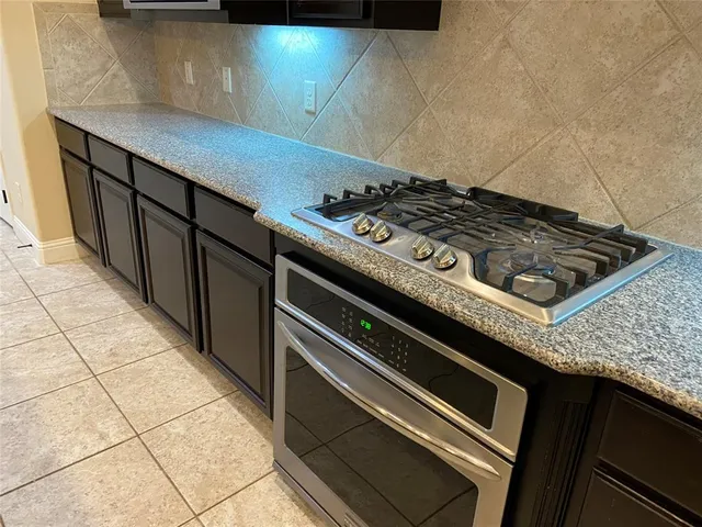 a stove top oven sitting inside of a kitchen