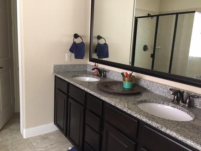 686 Pendle Forest Drive Frisco, TX 75036 - Photo 14 of 22 a bathroom with double vanity sinks and a mirror