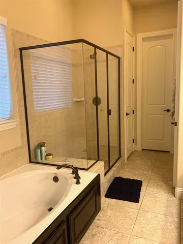 a bathroom with a tub sink and shower