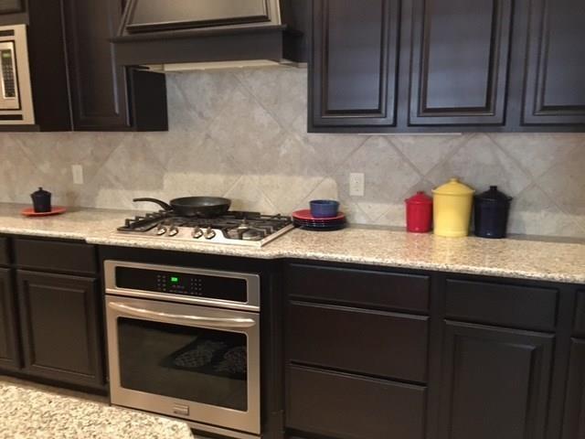 686 Pendle Forest Drive Frisco, TX 75036 - Photo 5 of 22 a kitchen with granite countertop cabinets stove and microwave