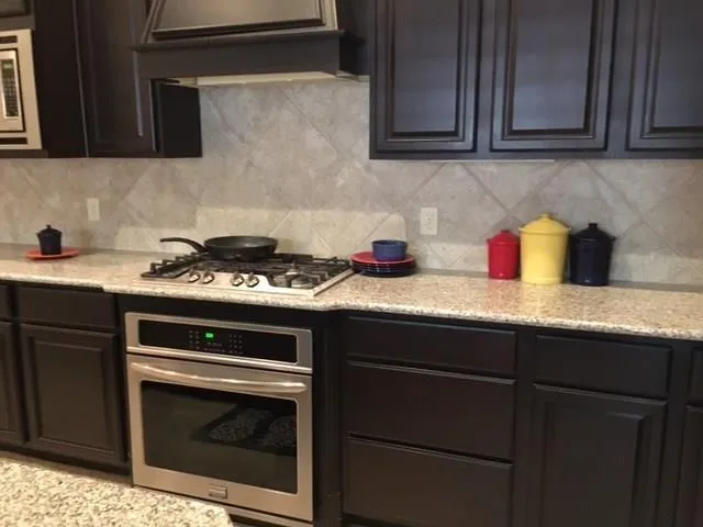 a kitchen with granite countertop cabinets stove and microwave