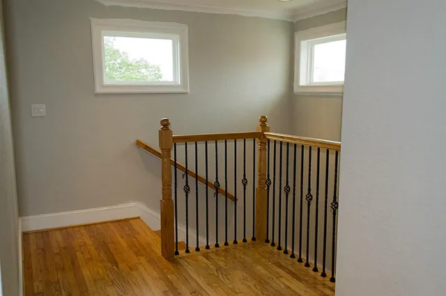 a view of a hallway with wooden floor and a window