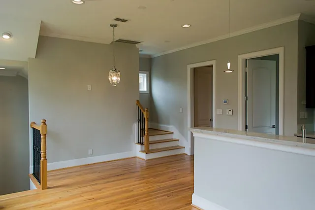 a view of a hallway with wooden floor and staircase