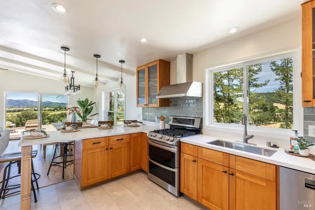 a kitchen with a table chairs stove and wooden floor