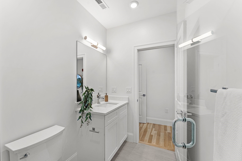 272 Lincoln Street, Unit 302 Marlborough, MA 01752 - Photo 21 of 27 a bathroom with a granite countertop sink a toilet and shower