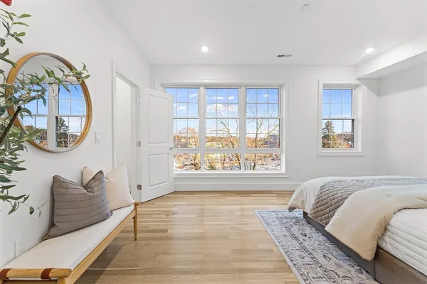 a spacious bedroom with a bed and a lamp