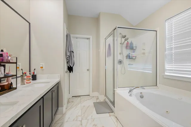 a bathroom with a tub a sink and a mirror