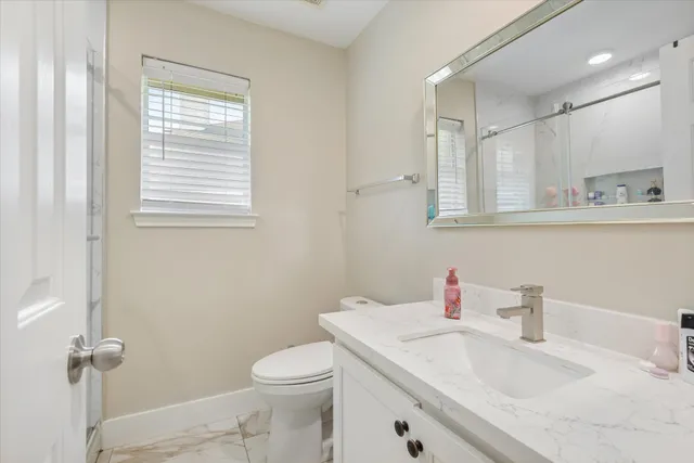 a bathroom with a sink a toilet and a mirror