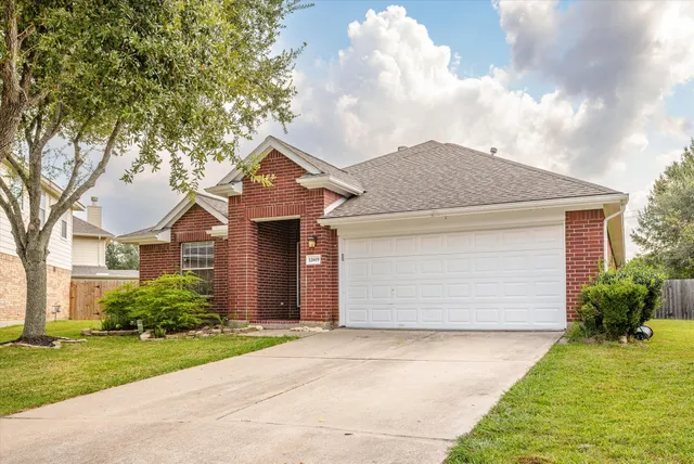 front view of house with a yard and trees around