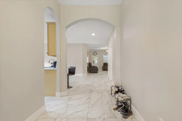 a view of a hallway with wooden floor and a bathroom