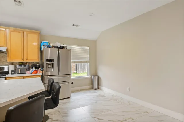 a view of a kitchen with a refrigerator cabinets and a wooden floor