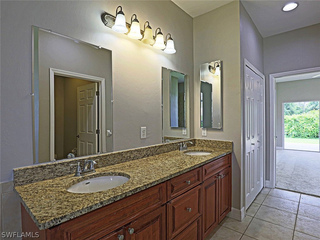 18242 Hemlock Road Fort Myers, FL 33967 - Photo 21 of 29 a bathroom with a granite countertop double vanity sink and a mirror